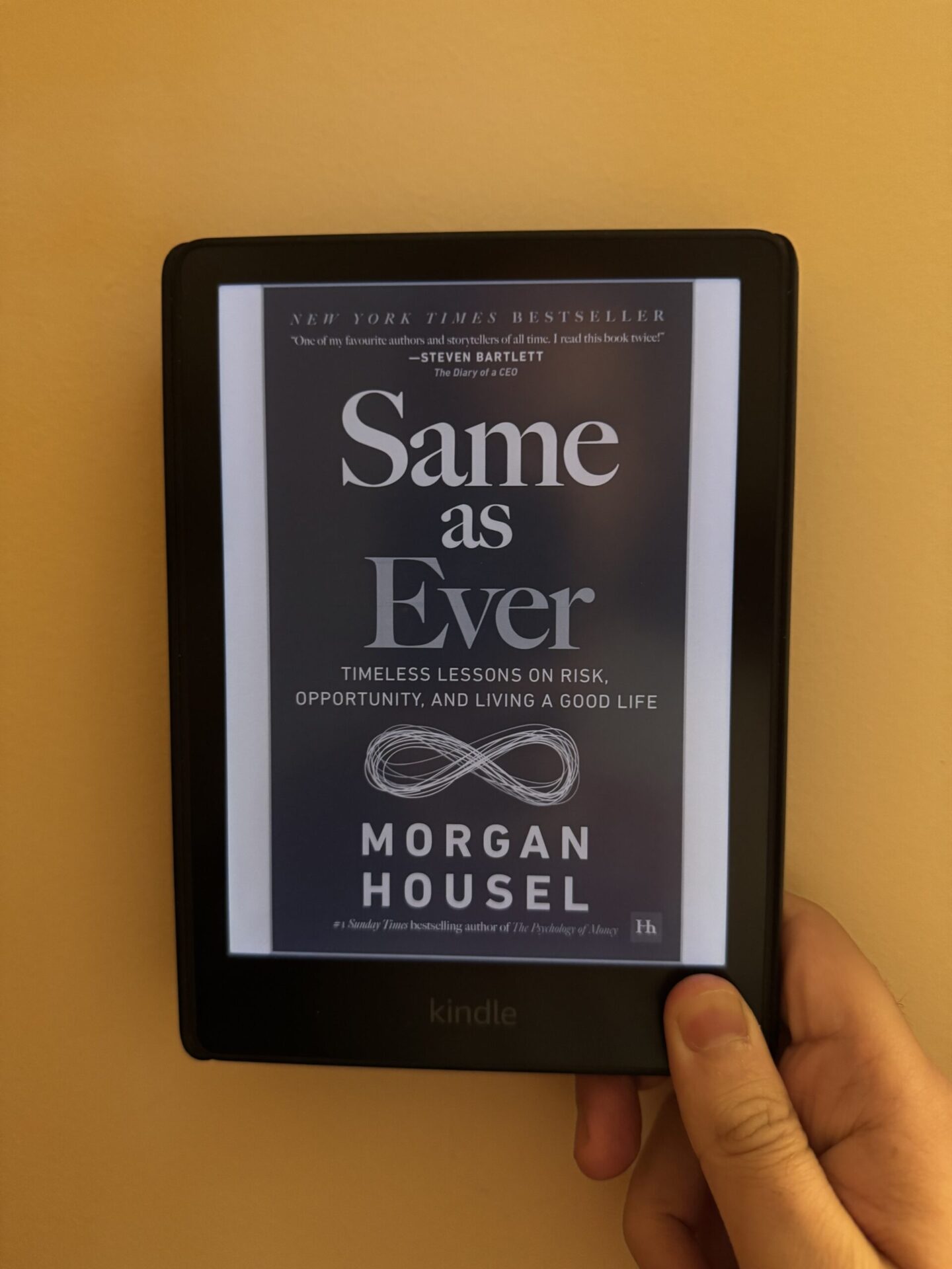 Tapan Desai holding the kindle edition of Same As Ever by Morgan Housel, as part of the book review.